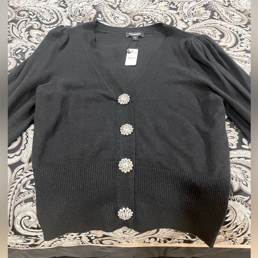 Cute black sweater with embellished buttons.